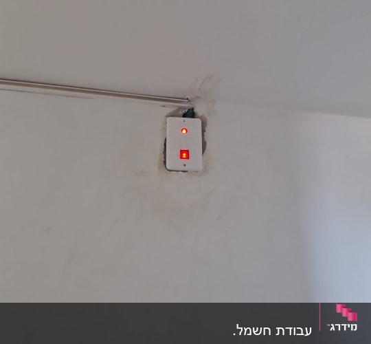 מתג חשמלי עם נורית חיווי על קיר